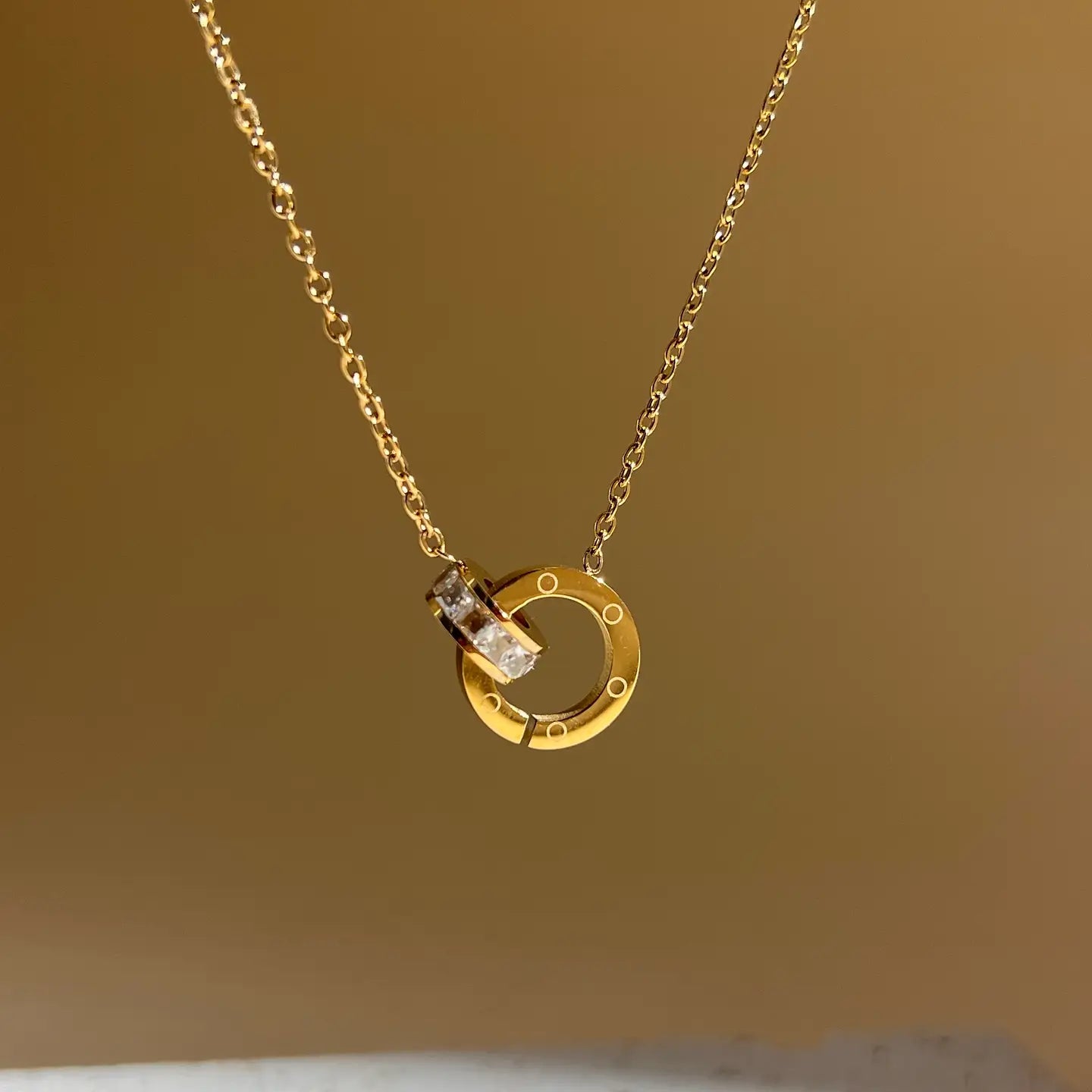 Collana con ciondolo rotondo intrecciato in acciaio inossidabile con strass.