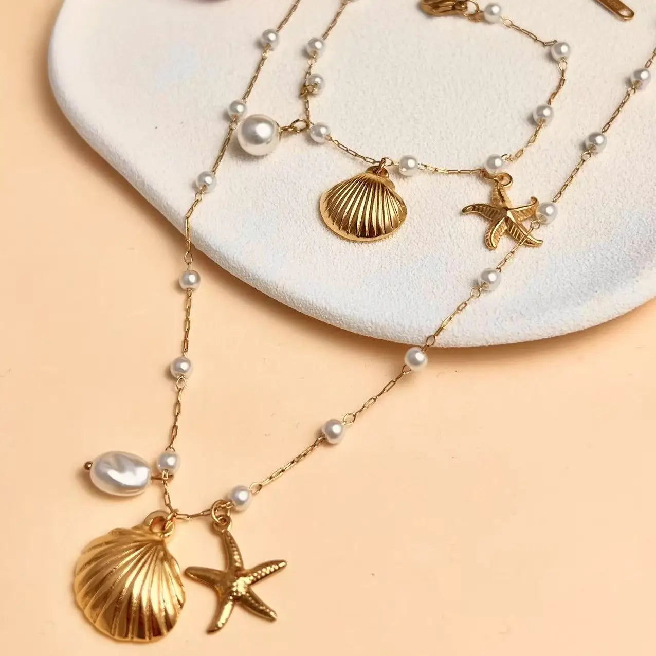 Set conchiglia stella marina perla acciaio inossidabile dorato.
