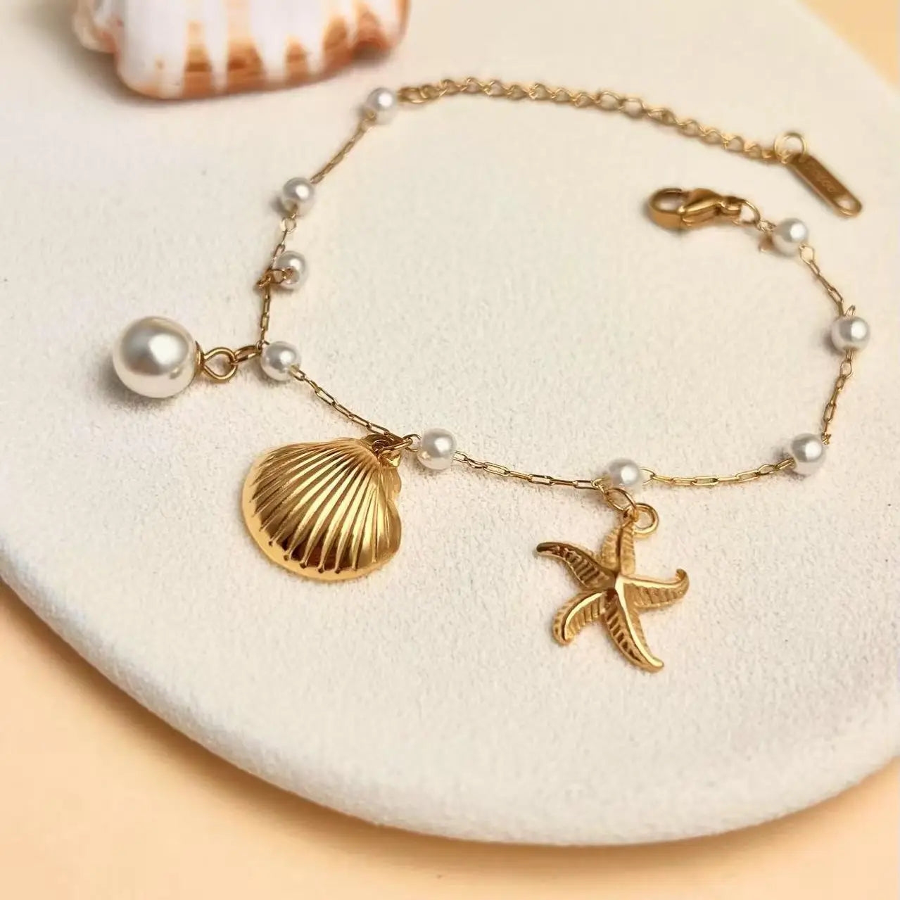 Set conchiglia stella marina perla acciaio inossidabile dorato.